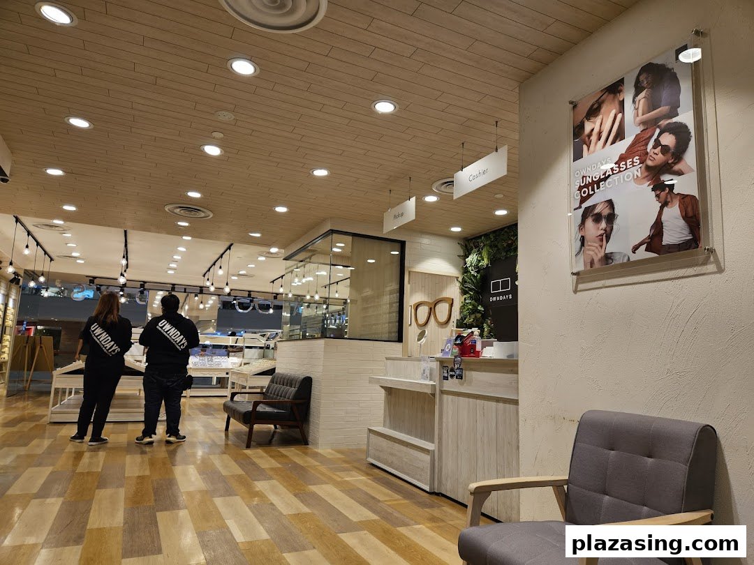 Interior view of OWNDAYS eyewear shop with staff, display cases, and a sunglasses collection poster.