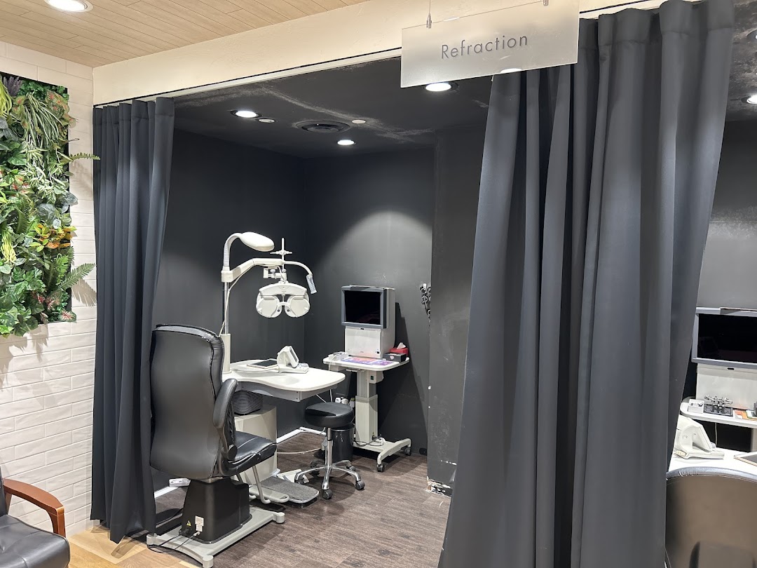 An eye examination room at OWNDAYS, featuring a phoropter, chair, and privacy curtains for refraction.
