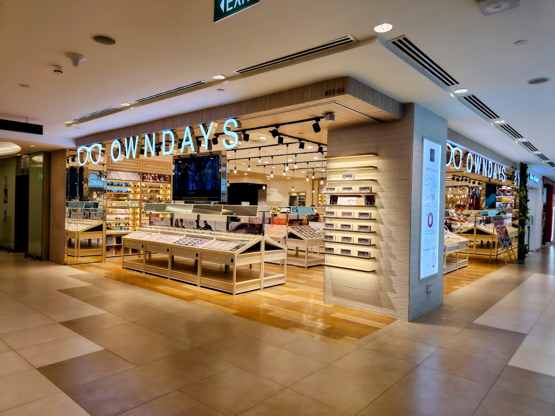A brightly lit OWNDAYS eyewear store interior with numerous glasses displays and a welcoming entrance.