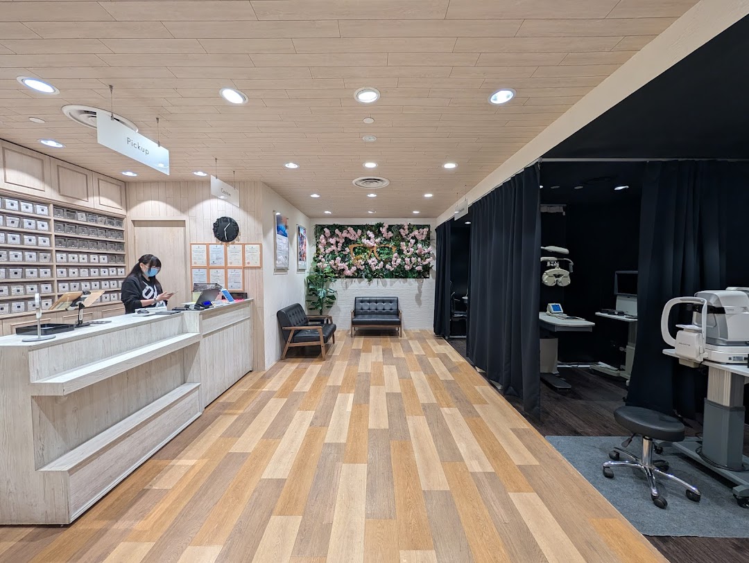 An optical shop interior featuring a reception desk, waiting area, and eye examination rooms.