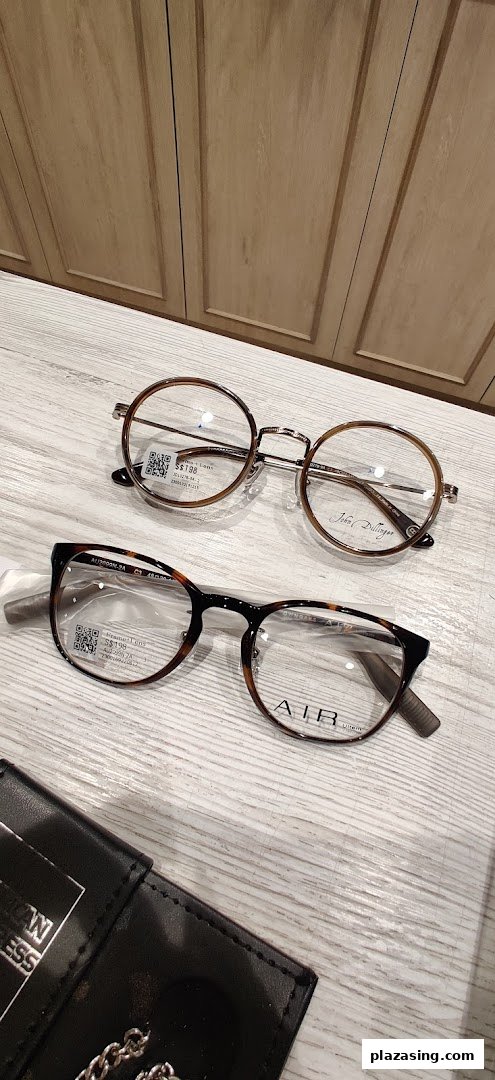 Two pairs of stylish eyeglasses, one round and one rectangular, displayed on a light wooden surface.