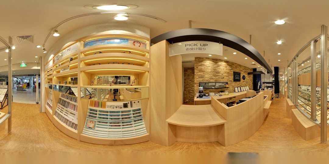 A panoramic view of OWNDAYS eyewear store interior, showcasing display shelves, a pick-up counter, and various glasses.