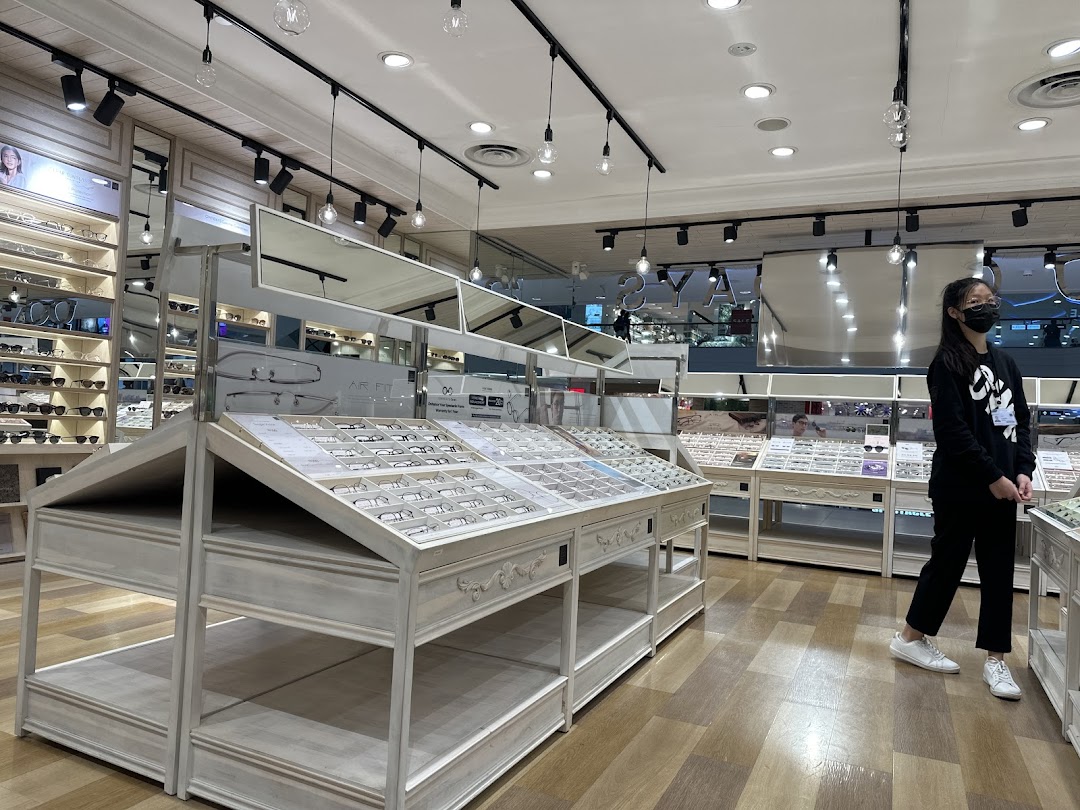 Interior view of OWNDAYS, showcasing numerous eyeglasses on display and a customer browsing the selection.
