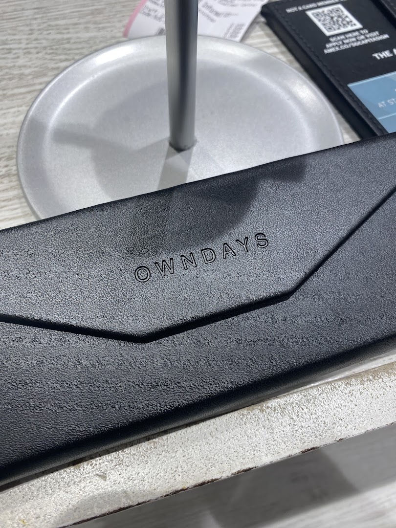 A close-up of a sleek black OWNDAYS eyeglass case with the brand logo.