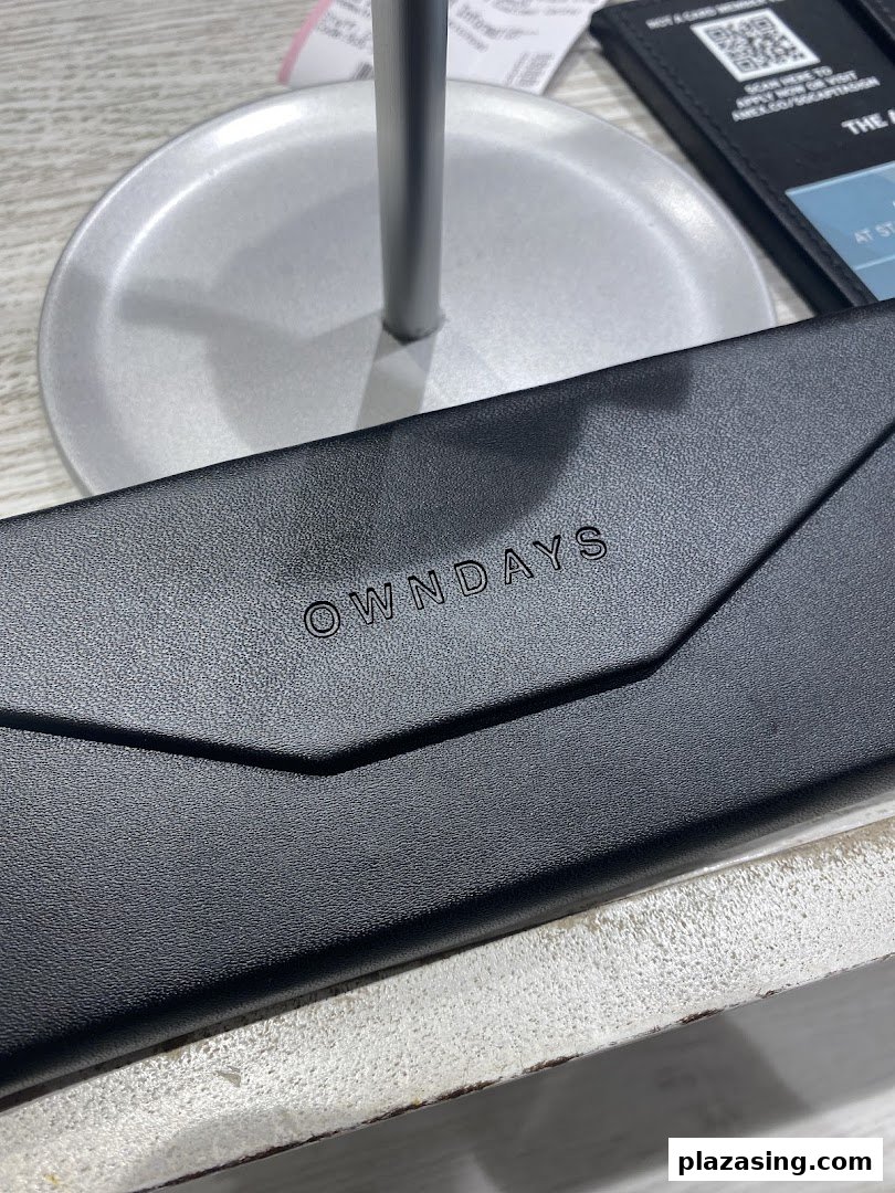 A close-up of a sleek black OWNDAYS eyeglass case with the brand logo.