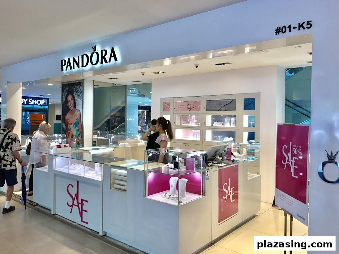 The bright, modern storefront of Pandora jewelry store with customers browsing and sale signs.