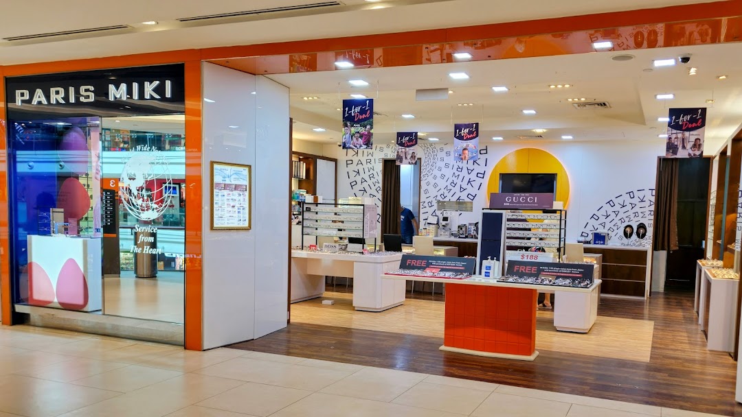 The storefront and interior of Paris Miki, an optical shop, featuring eyewear displays and promotional banners.