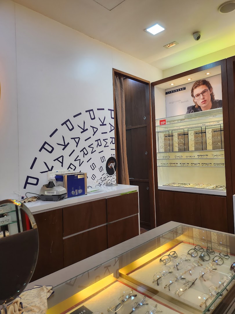 Interior view of Paris Miki optician, showcasing eyewear displays, eye care equipment, and a Lindberg advertisement.