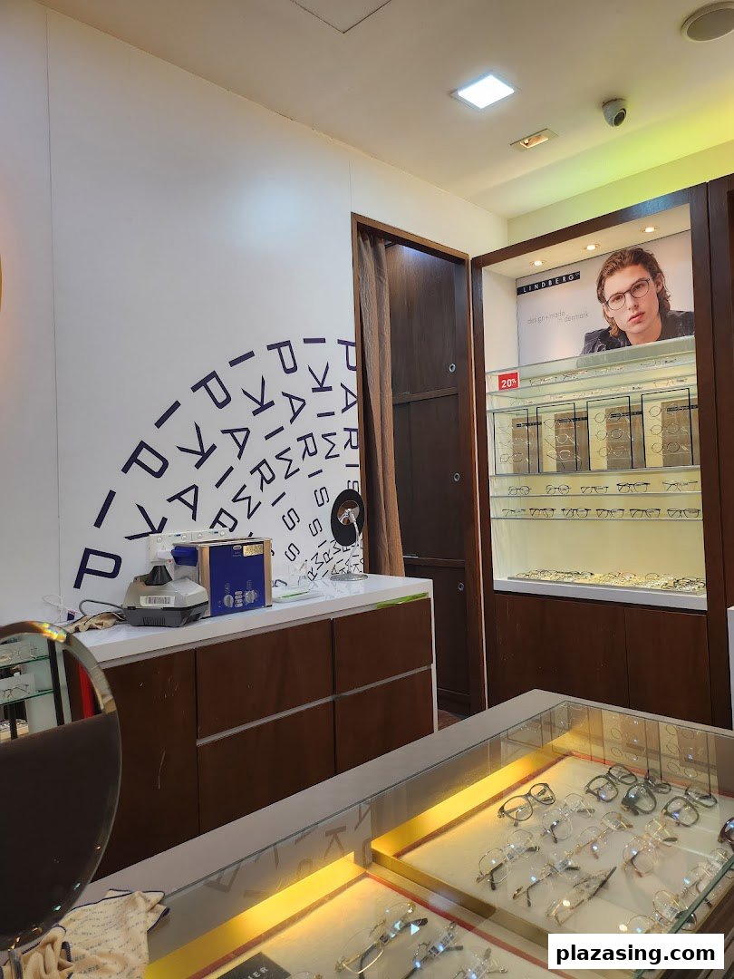 Interior view of Paris Miki optician, showcasing eyewear displays, eye care equipment, and a Lindberg advertisement.