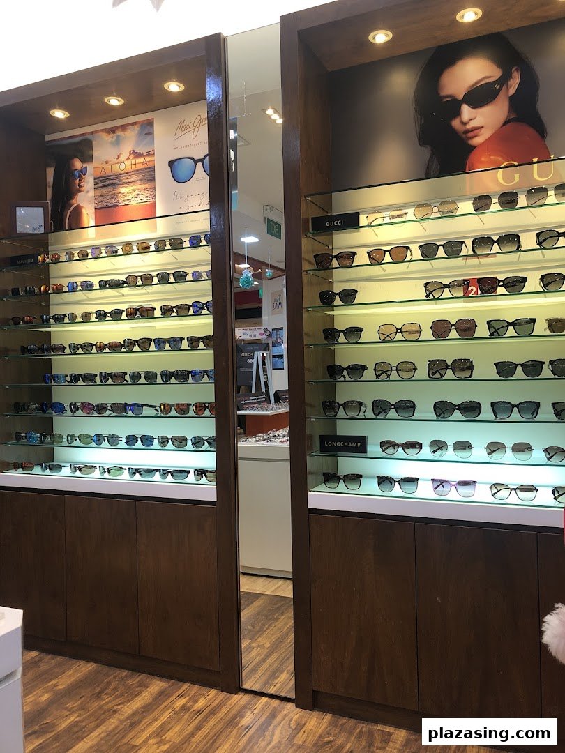 Brightly lit display cases showcase a wide selection of sunglasses from various brands like Gucci and Maui Jim.