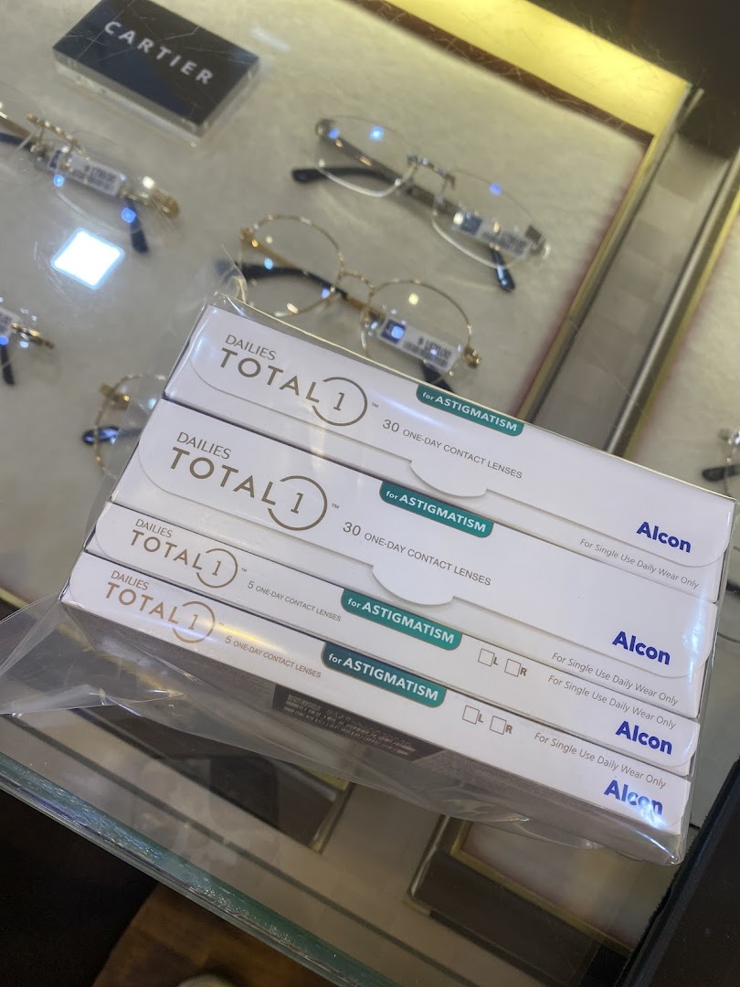 Boxes of Dailies Total 1 contact lenses and spectacles displayed in an optical shop.