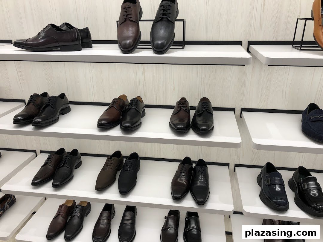 A display of various men's dress shoes and loafers on white shelves inside the PEDRO store.