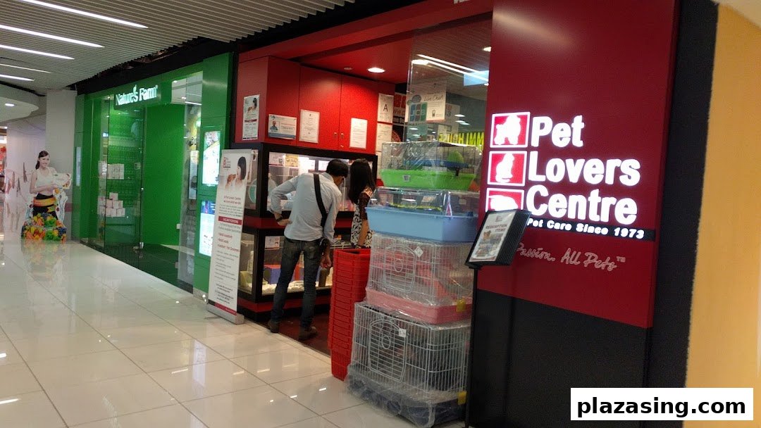 The Pet Lovers Centre shop front at Plaza Singapura, featuring pet cages and customers browsing.