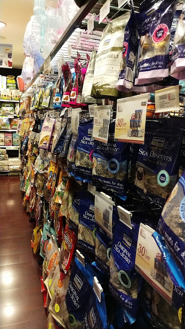 An aisle in Pet Lovers Centre showcasing a wide variety of packaged pet treats and food.
