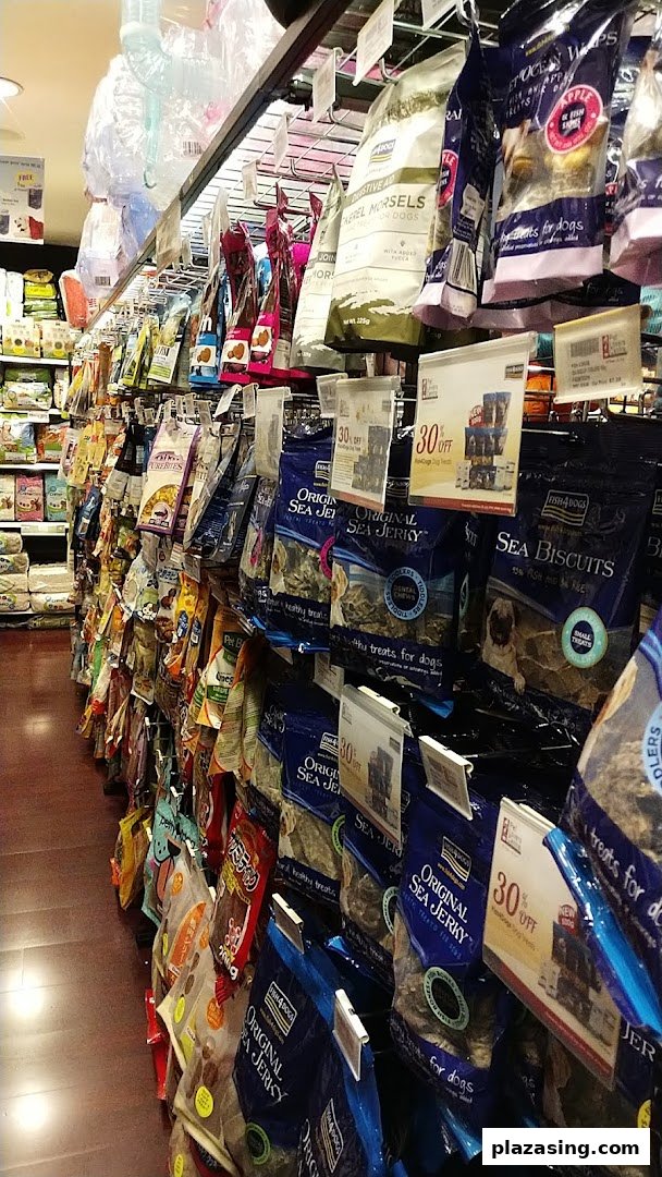 An aisle in Pet Lovers Centre showcasing a wide variety of packaged pet treats and food.