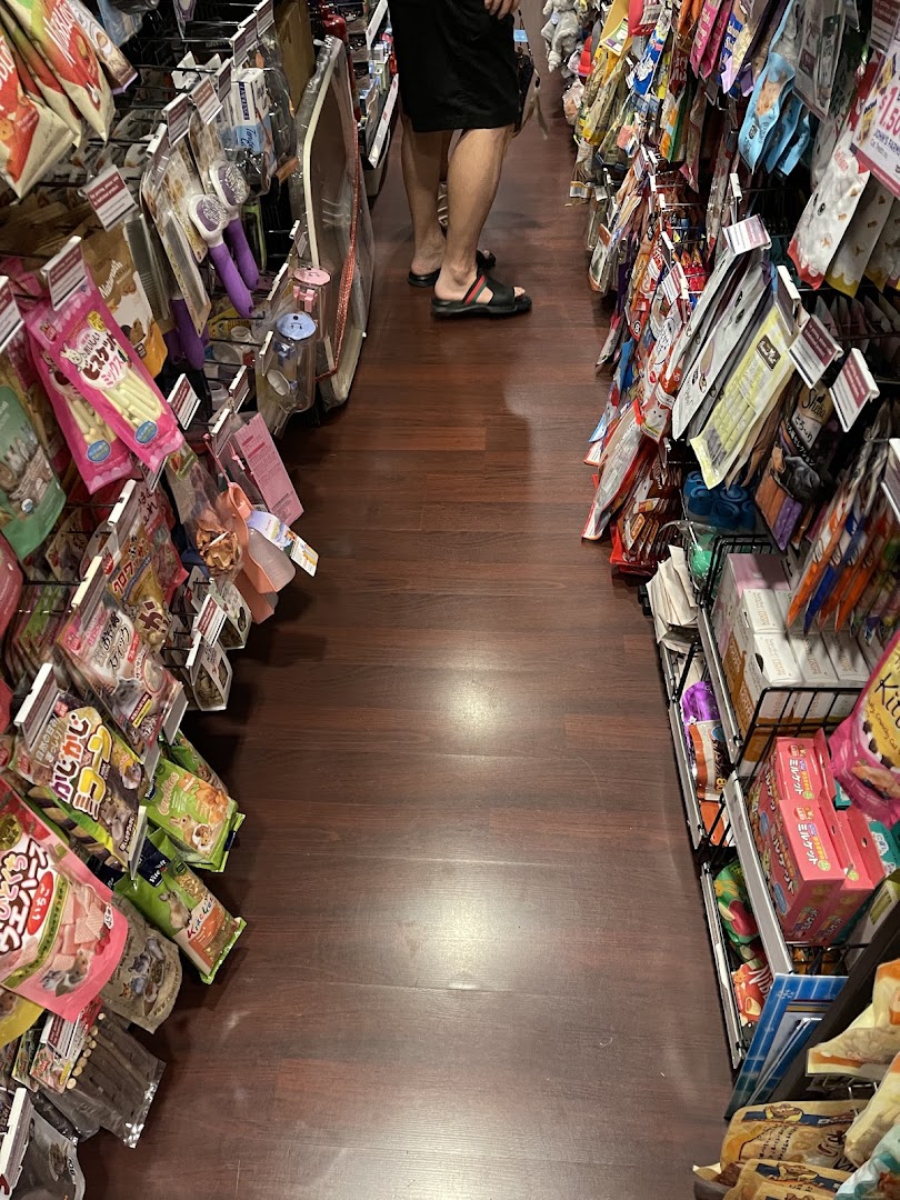 An aisle inside Pet Lovers Centre, showcasing shelves packed with various pet products and treats.
