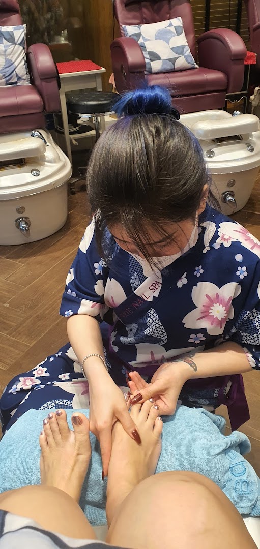 A nail technician performing a pedicure on a client in a comfortable spa setting.