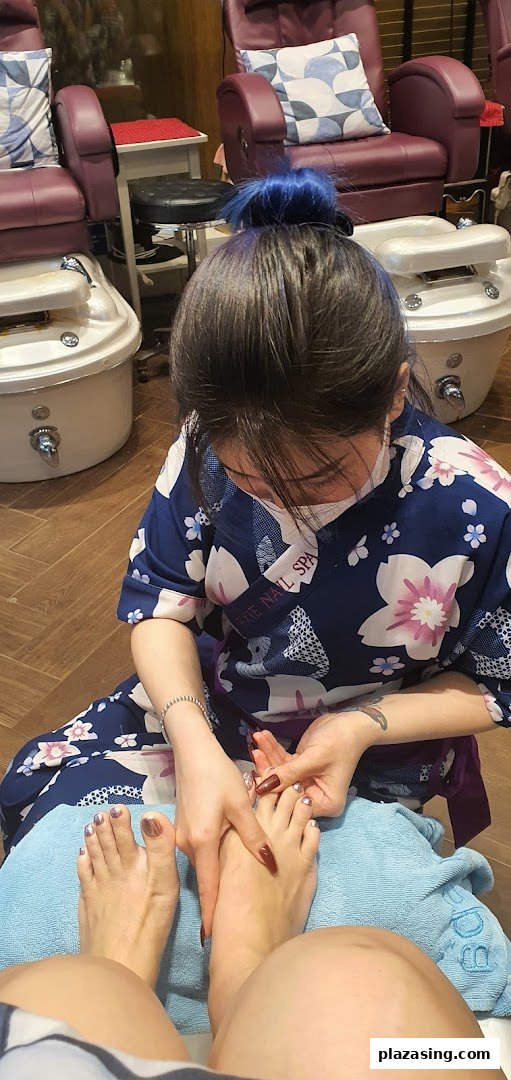 A nail technician performing a pedicure on a client in a comfortable spa setting.
