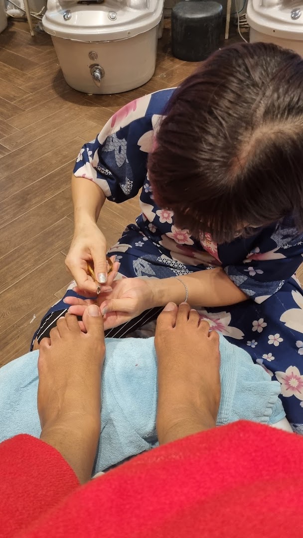 A close-up view of a customer receiving a pedicure service at a nail spa.