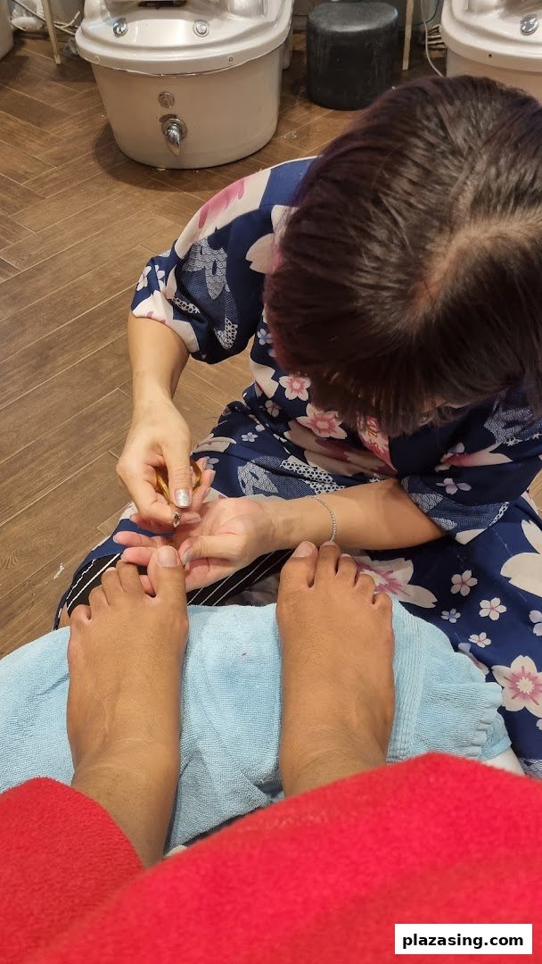 A close-up view of a customer receiving a pedicure service at a nail spa.