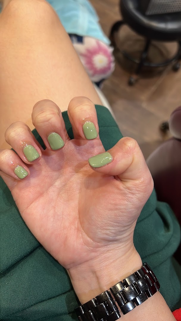A close-up of a hand with freshly manicured nails in a stylish sage green polish.