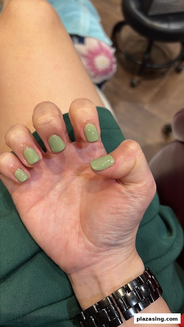 A close-up of a hand with freshly manicured nails in a stylish sage green polish.