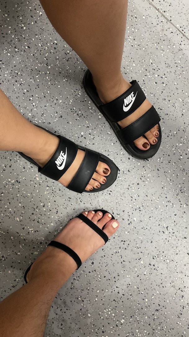 Close-up of three pairs of feet showcasing fresh pedicures with various nail polish colors.