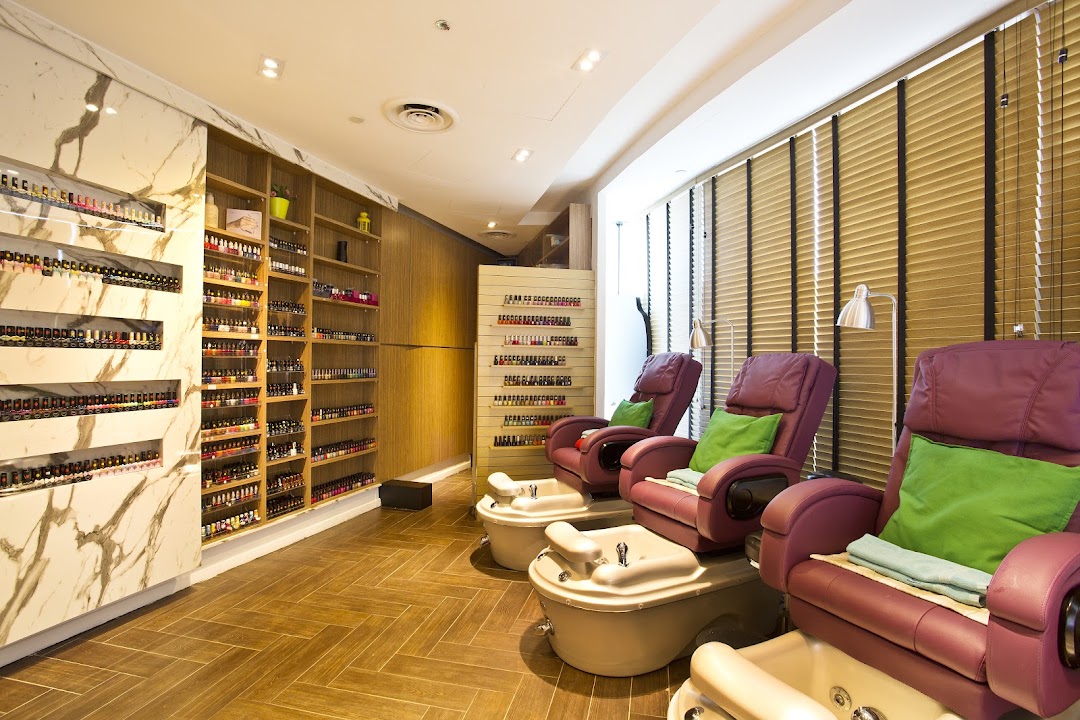Interior view of Pixie Nail Spa featuring comfortable pedicure chairs and extensive nail polish displays.