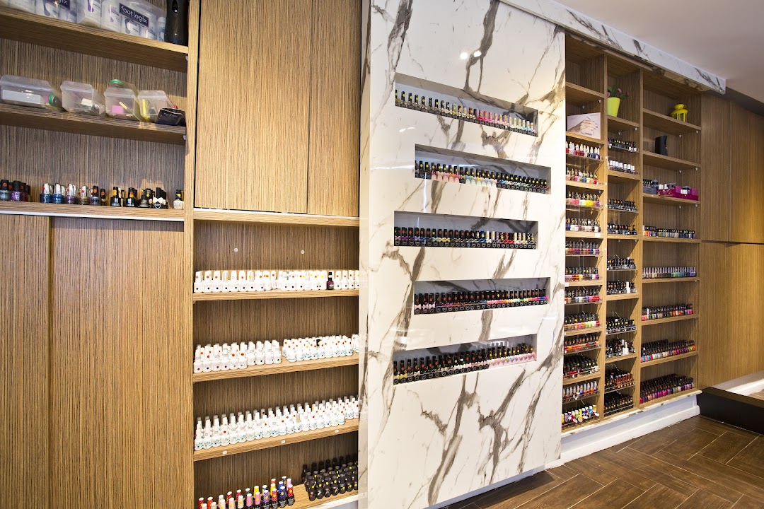 Interior view of Pixie Nail Spa showcasing extensive nail polish collections on stylish shelves.