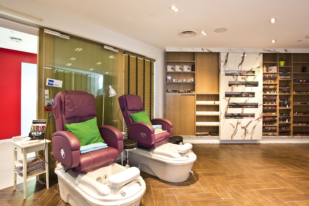 Interior view of a nail spa featuring two pedicure stations and extensive nail polish displays.