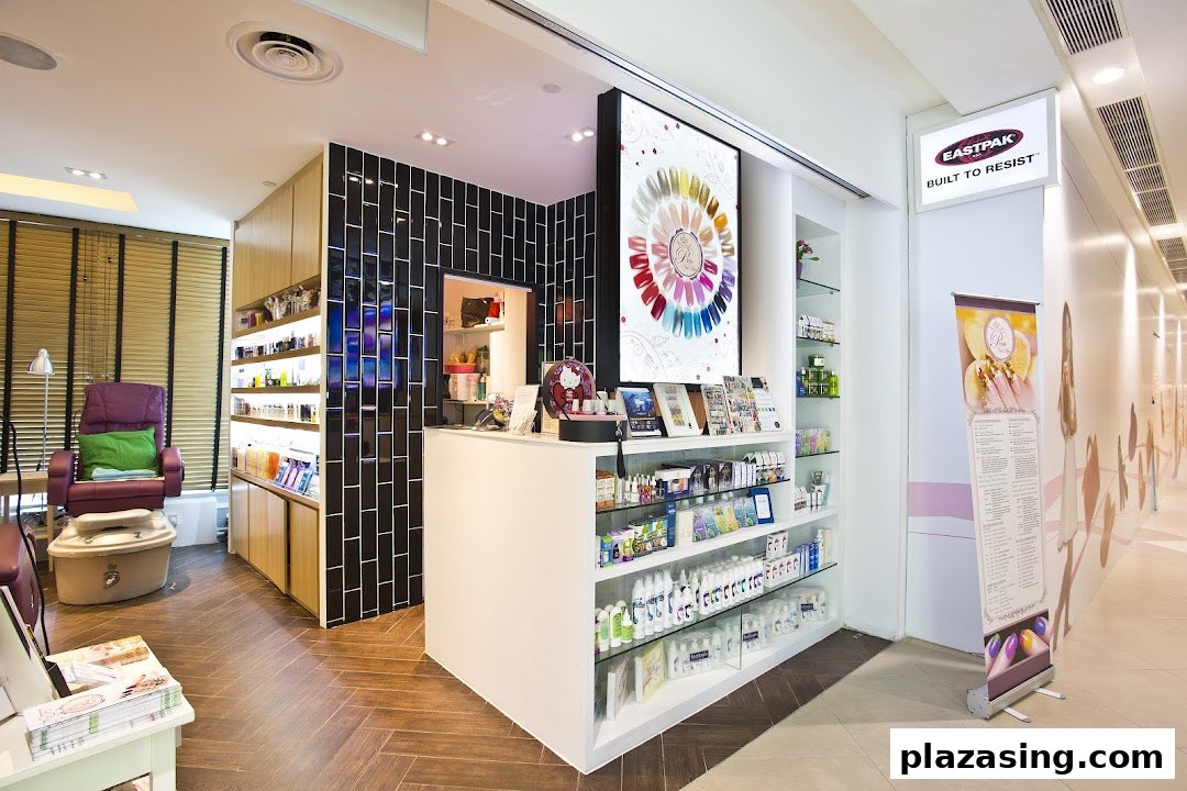 Interior view of a modern nail spa featuring a reception desk, product displays, and a pedicure station.