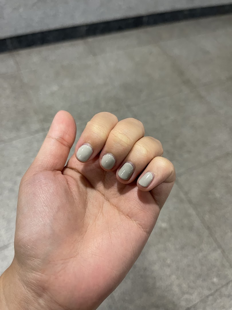 A hand showcasing freshly painted nails with a chic, neutral polish.