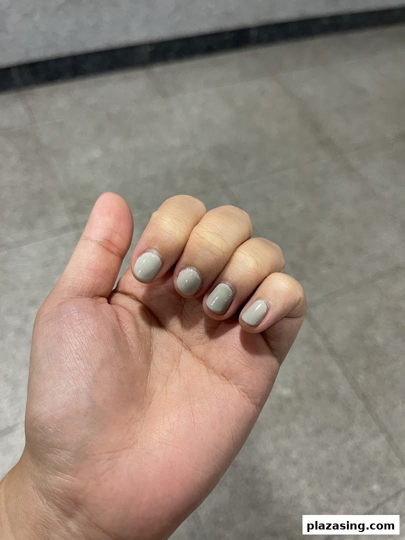 A hand showcasing freshly painted nails with a chic, neutral polish.