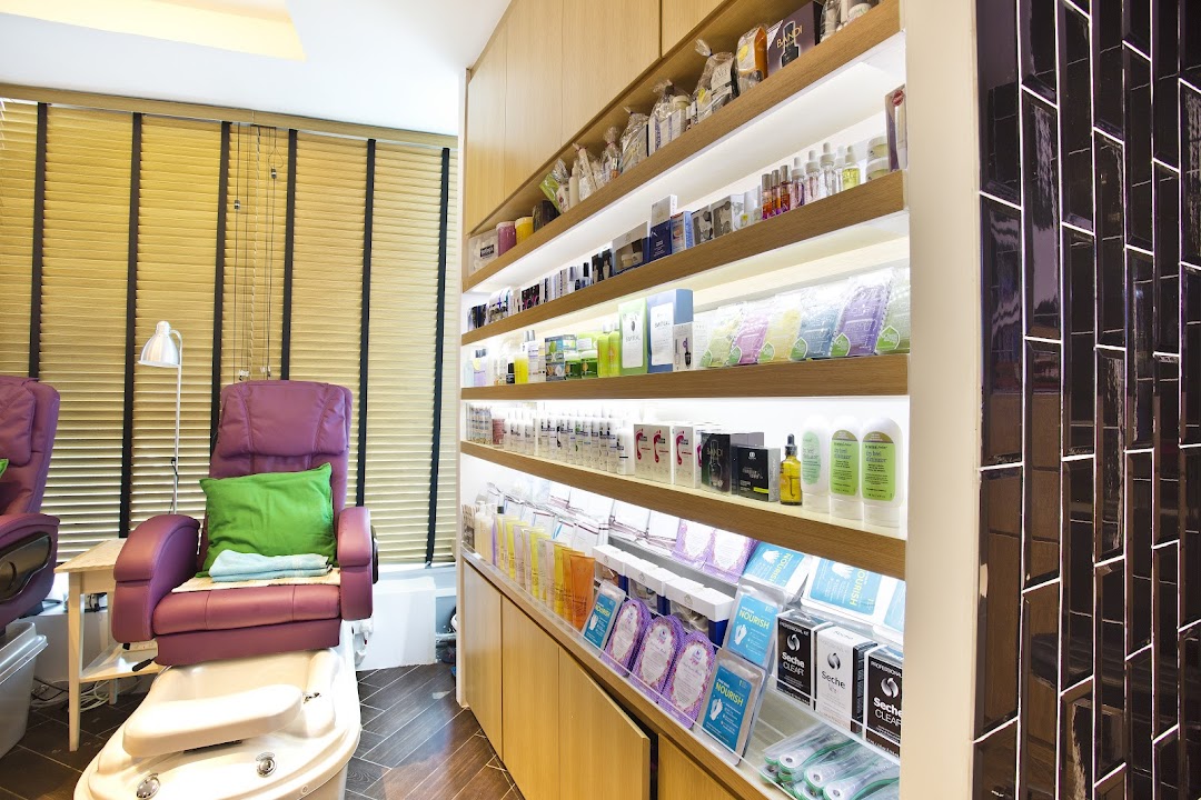 Interior view of Pixie Nail Spa, featuring a comfortable pedicure station and illuminated product display shelves.