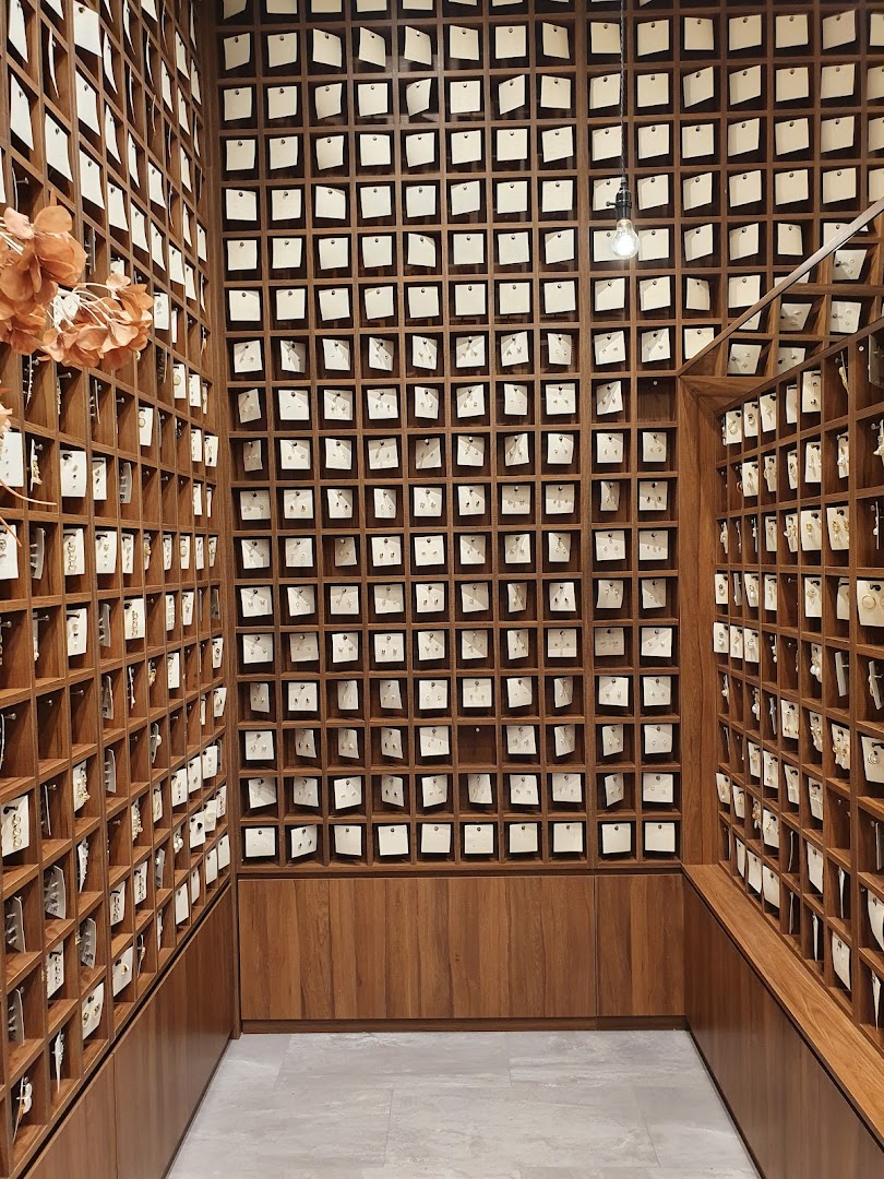 Interior view of Playdress showcasing a vast collection of earrings displayed in individual wooden cubbies.