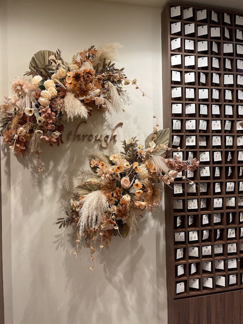 A stylish wall display featuring dried floral arrangements and an array of earrings.