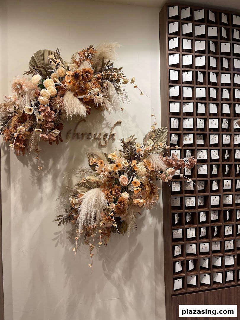 A stylish wall display featuring dried floral arrangements and an array of earrings.