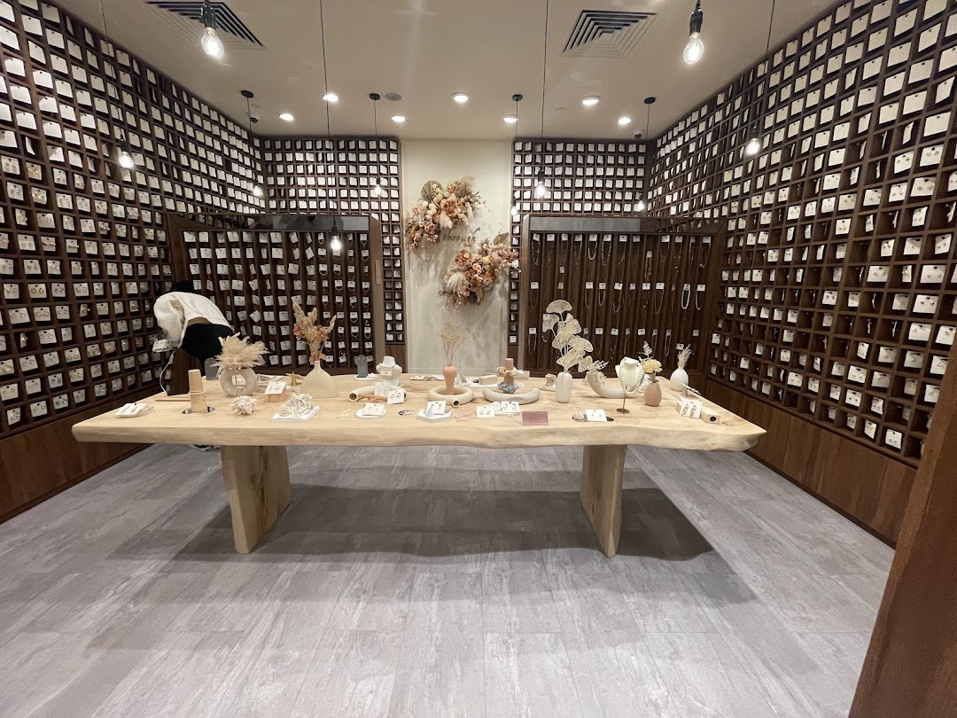An interior view of Playdress Plaza Singapura, featuring a large wooden display table and walls filled with accessories.