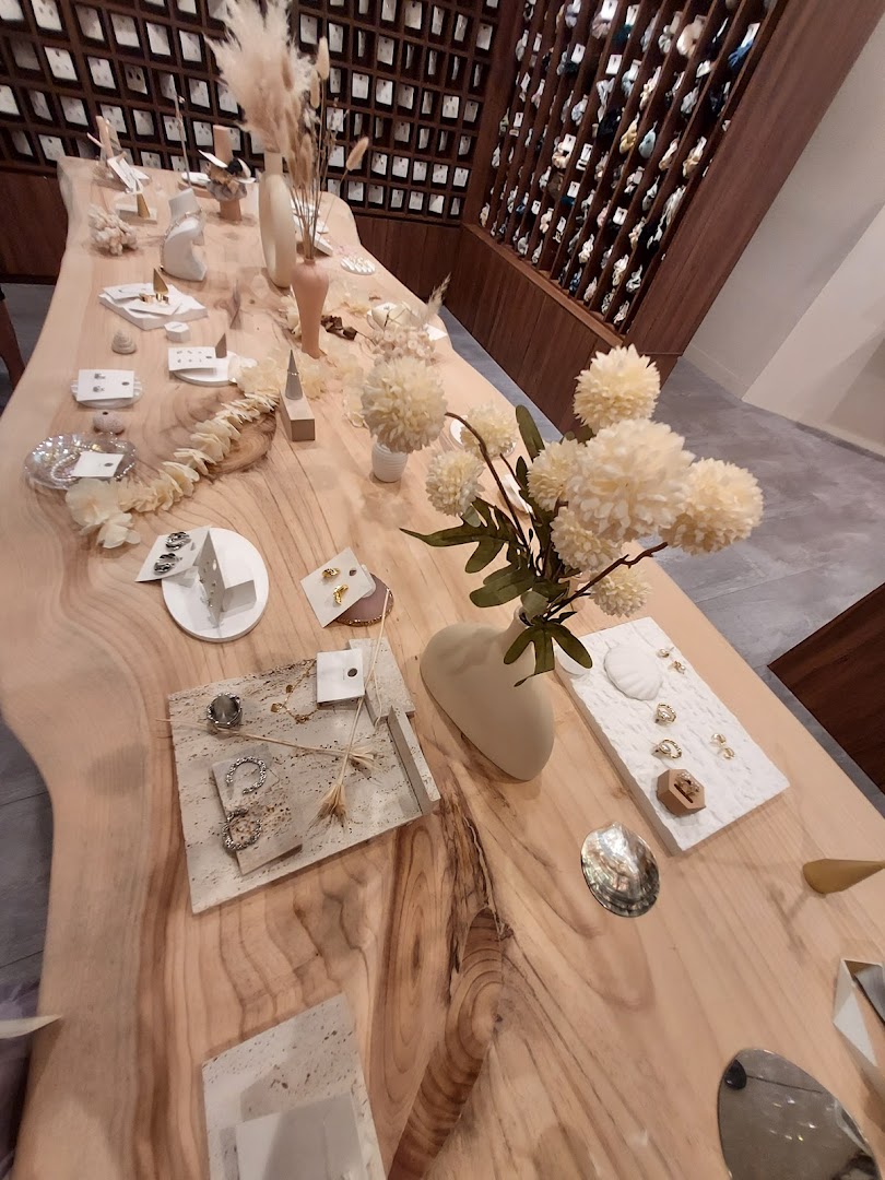 An elegant wooden display table showcasing accessories and jewelry inside Playdress Plaza Singapura.