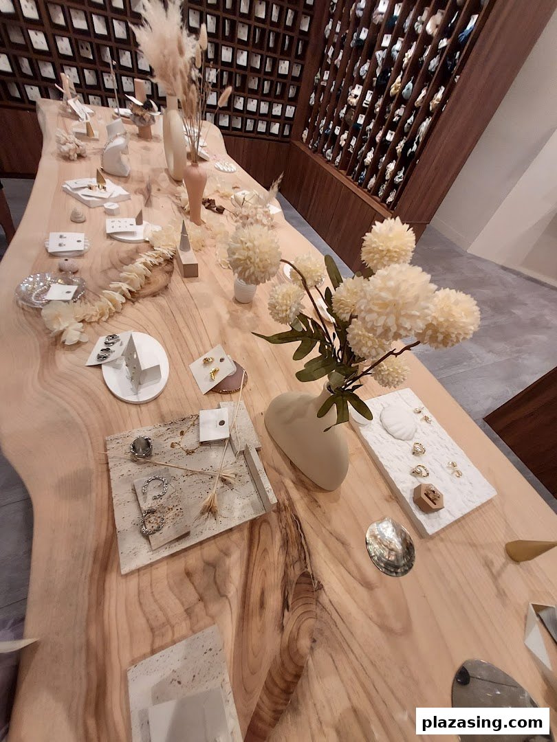 An elegant wooden display table showcasing accessories and jewelry inside Playdress Plaza Singapura.