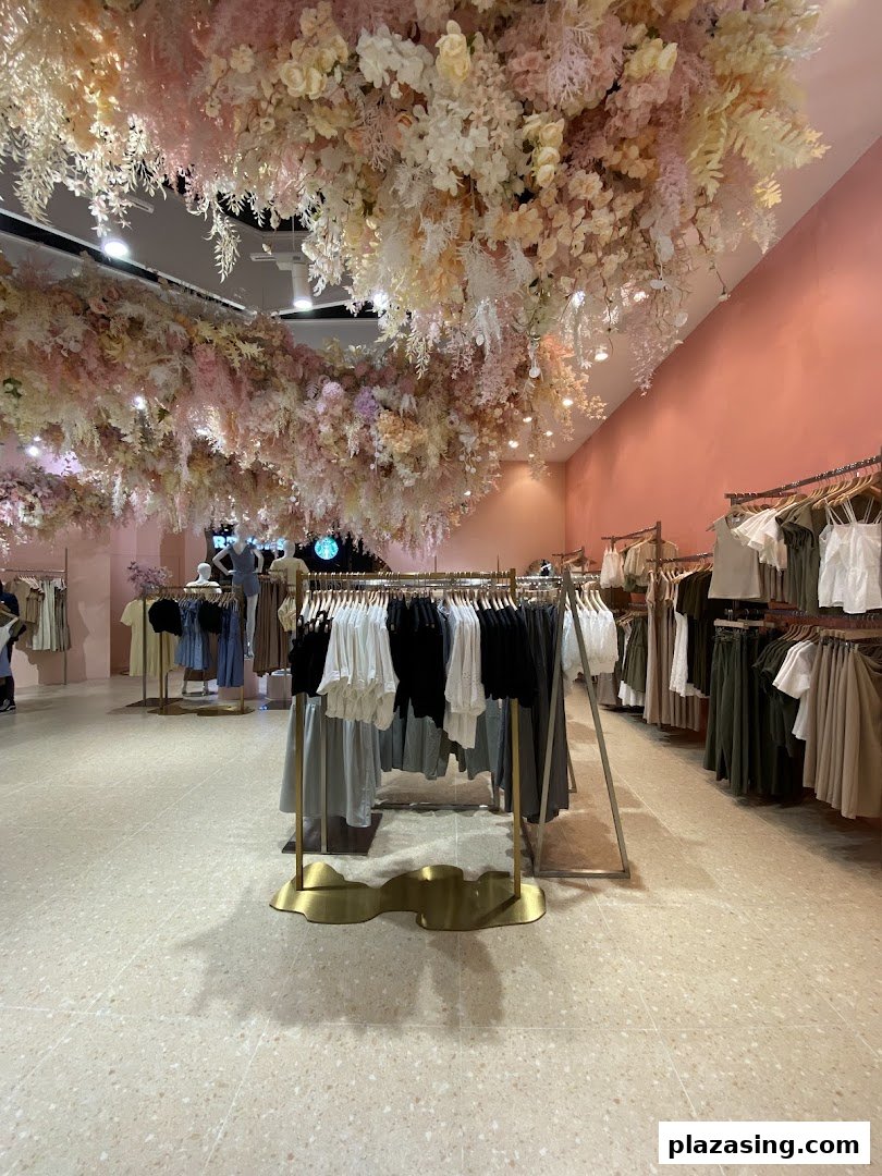Interior of Playdress Plaza Singapura featuring clothing racks and an elaborate floral ceiling installation.