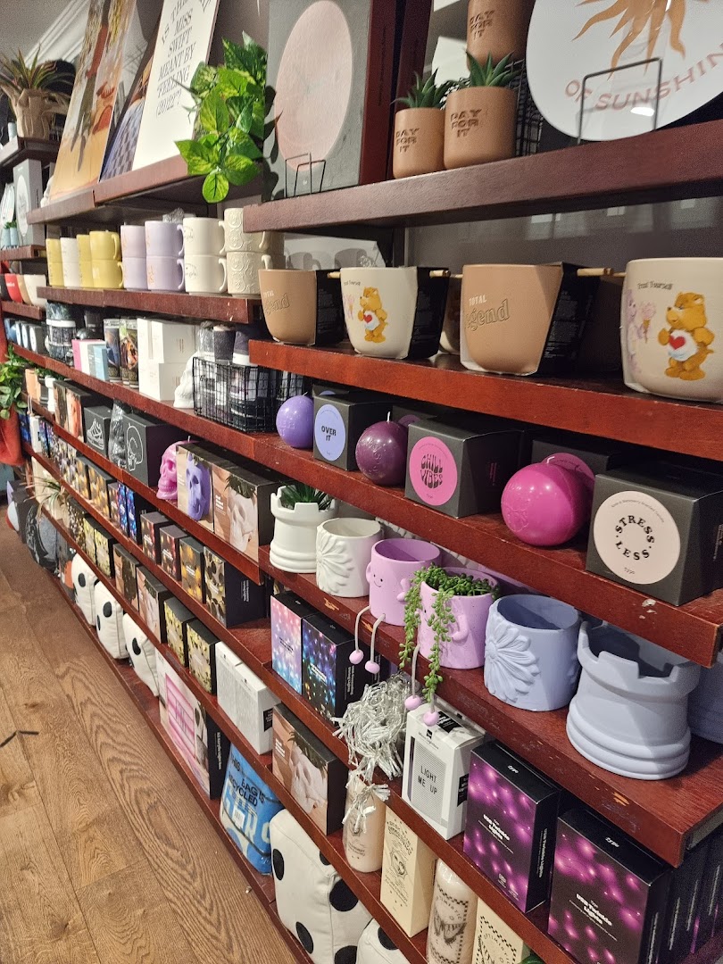 Shelves filled with a diverse range of lifestyle products, including mugs, candles, and decorative items.