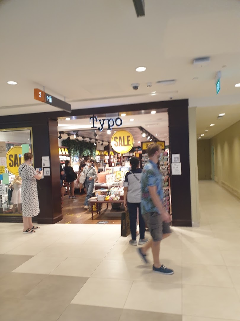 The image shows the bustling entrance of Typo at Plaza Singapura, with shoppers entering and browsing.
