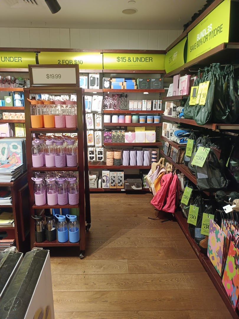 An interior view of Typo, showcasing colorful stationery, drinkware, and gift items on display shelves.