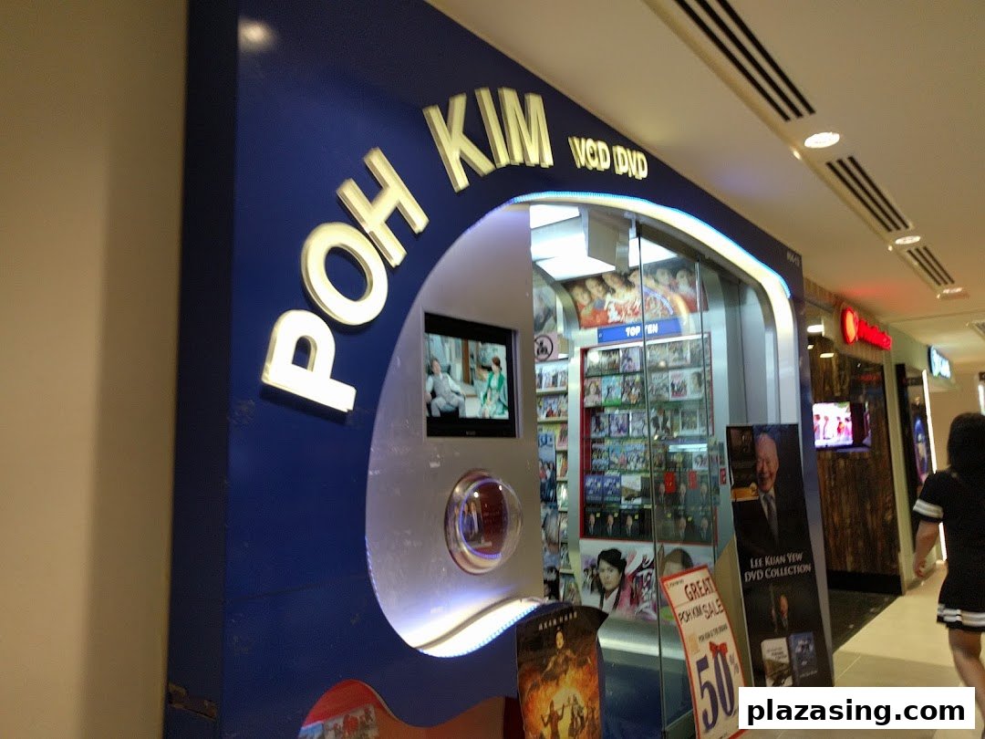 The illuminated entrance of Poh Kim, a VCD and DVD shop, showcasing its media collection and promotions.