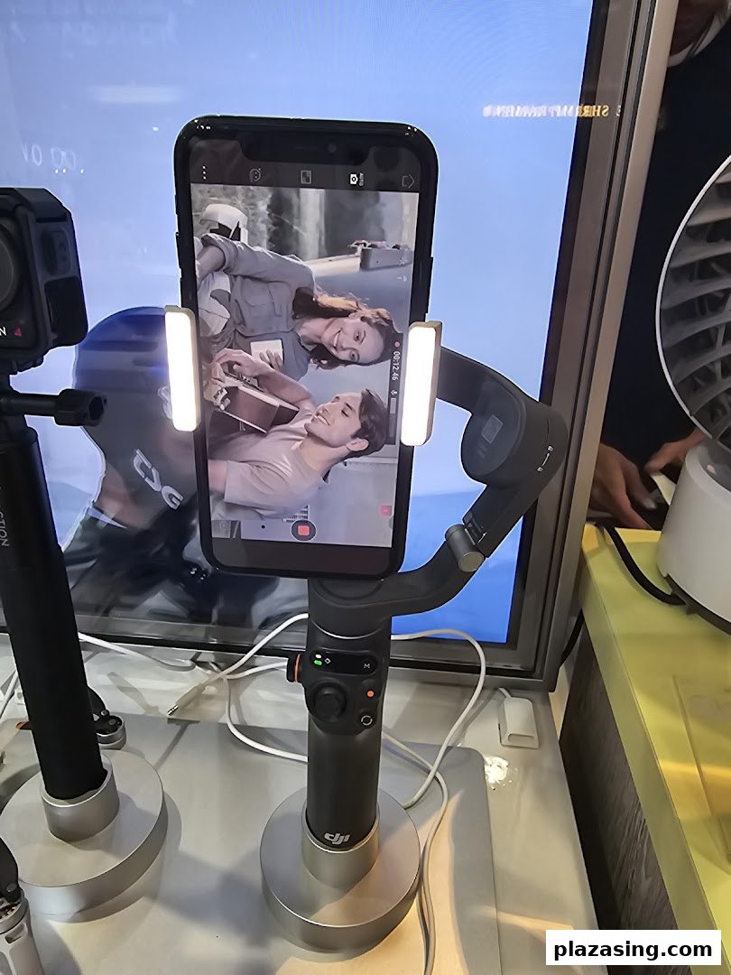 A smartphone mounted on a gimbal with attached lights, displaying a video of two people.