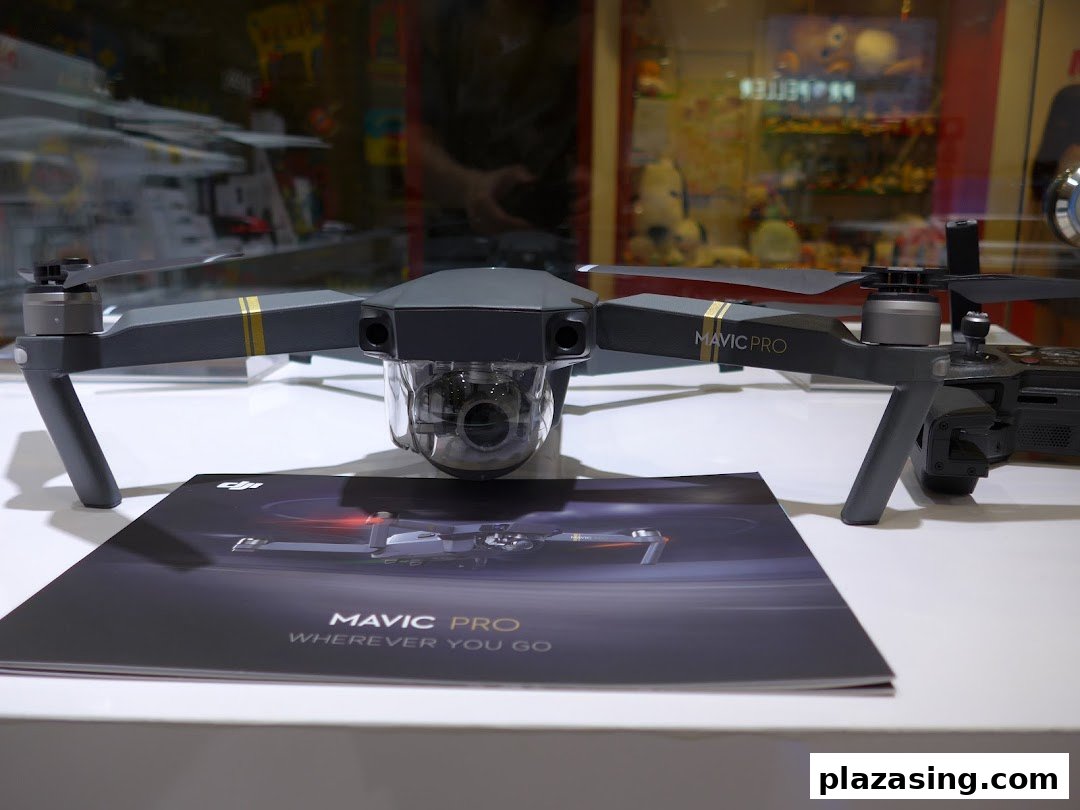 A DJI Mavic Pro drone displayed on a white surface with its brochure in a retail setting.