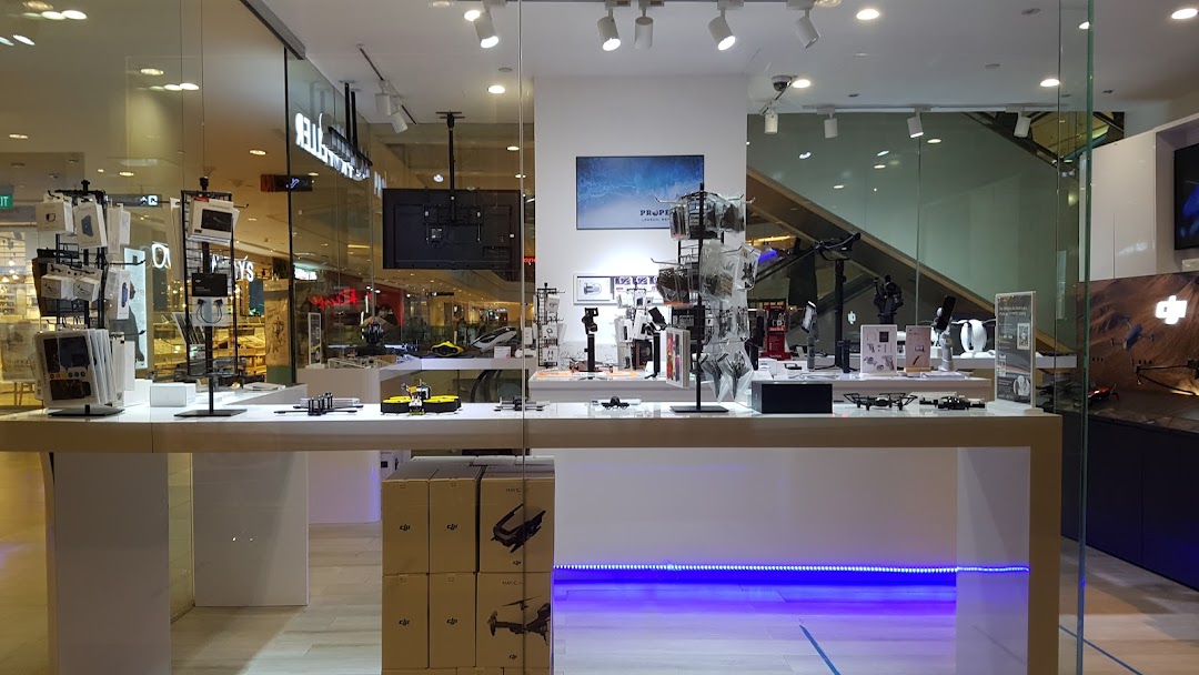 A modern retail store interior showcasing drones, accessories, and tech gadgets on display.