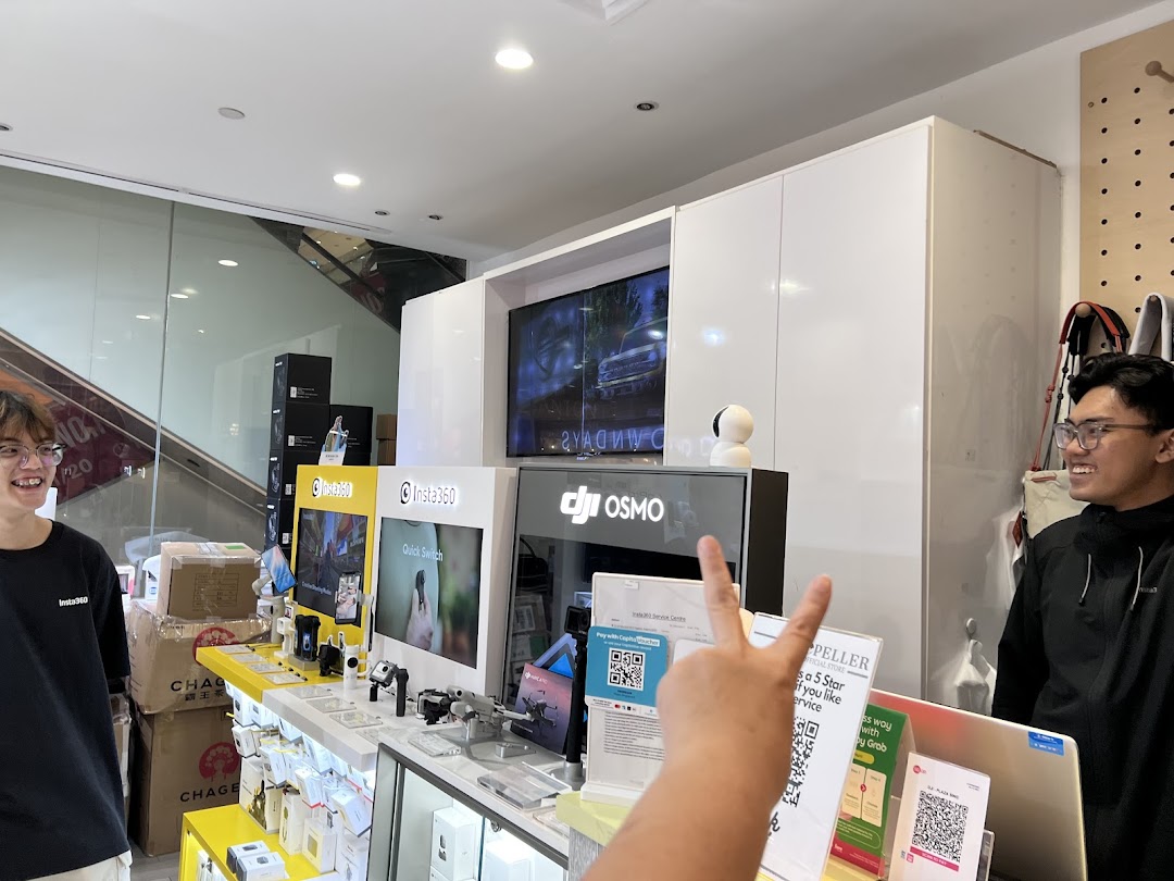 Interior view of Propeller Singapore, an electronics shop featuring Insta360 and DJI products, with staff present.