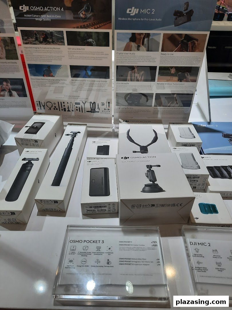 A display of DJI cameras, microphones, and accessories with promotional posters in a retail shop.